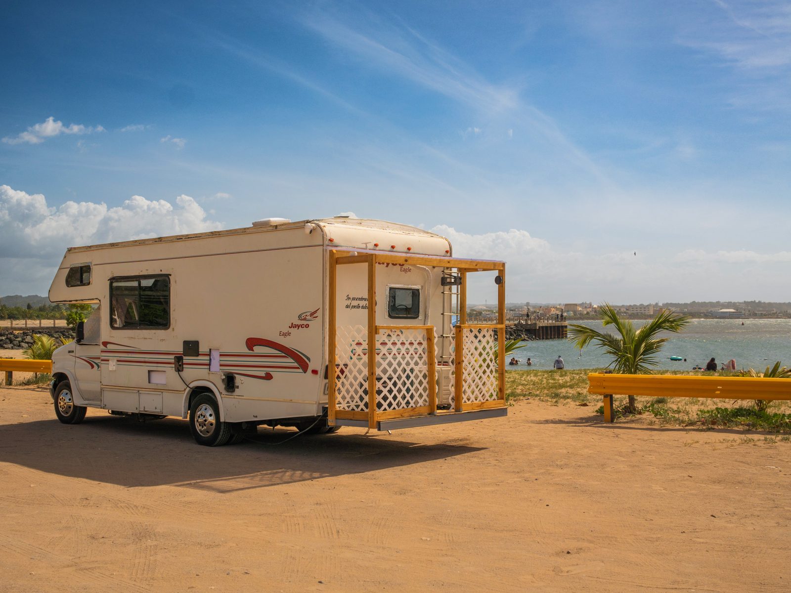 Vista lateral del motorhome con su terracita y la bahía detrás