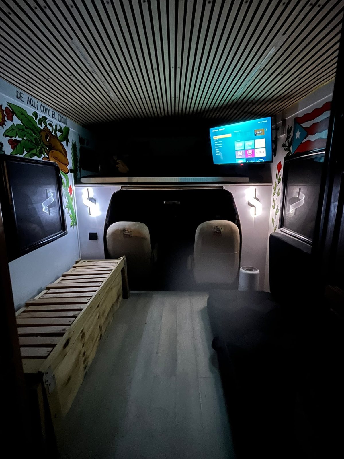 Zona de cine con TV y mural De aquí como el coquí